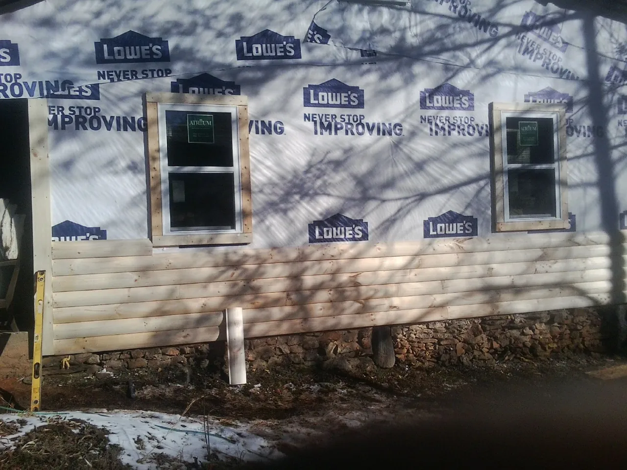 House wrap and new log siding going up on an exterior wall in South Lebanon