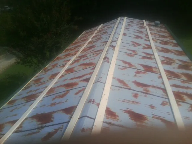 Rusted metal roof panels with new wood purlins before replacement — Storm Damage Roof Repair in South Lebanon by Roofing Brothers