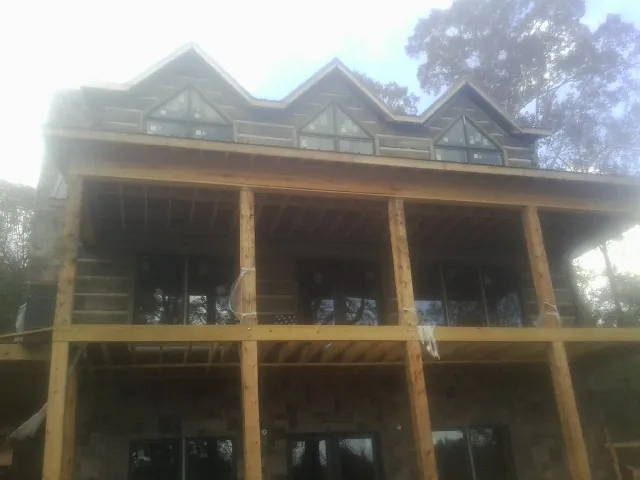 Dormers and porch framing on a large log home under construction — Roof Coating work by our crew in South Lebanon