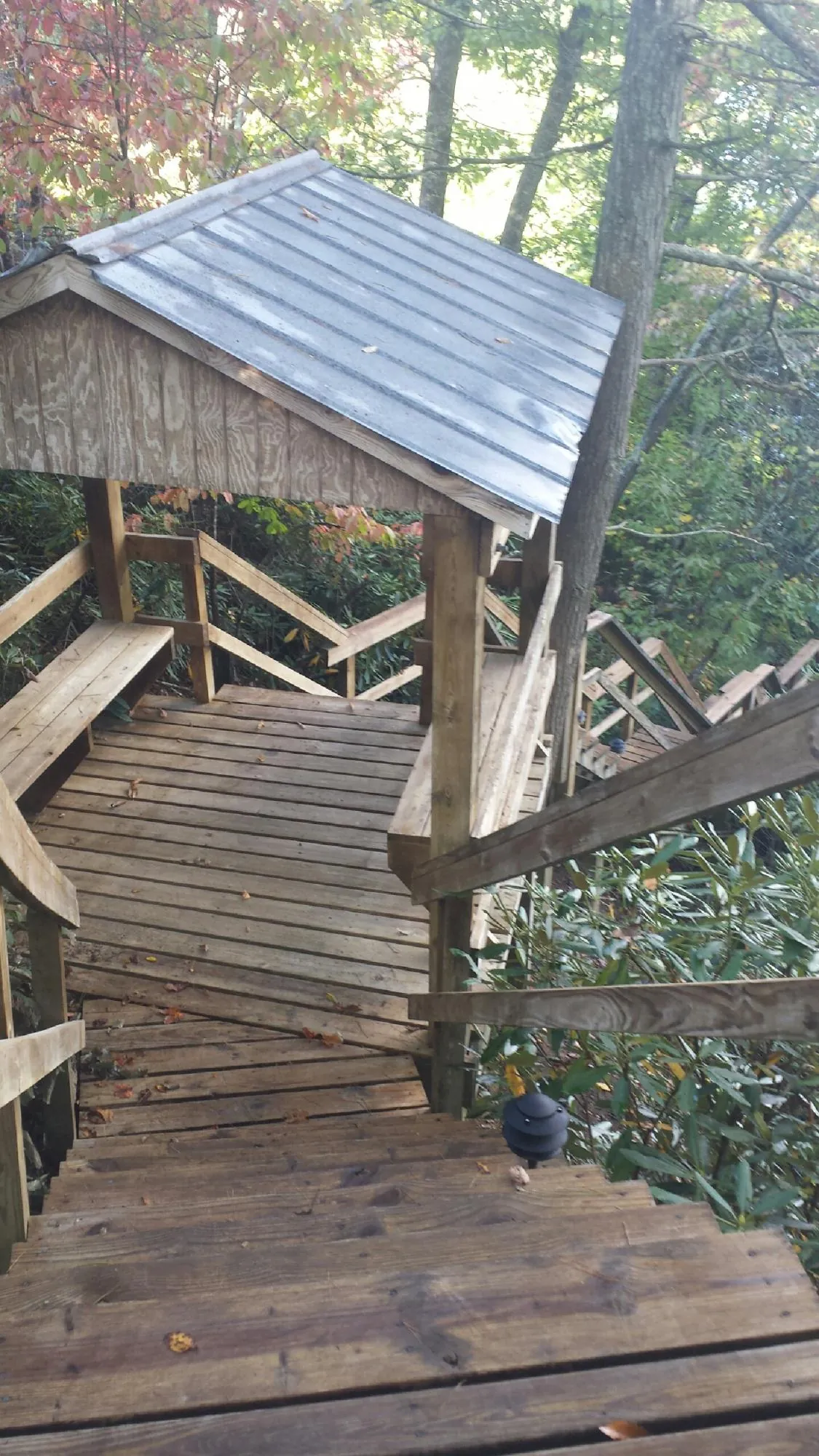 Metal roofed shelter over wooden steps on a wooded walkway — Skylight Repair & Installation work by our crew in South Lebanon