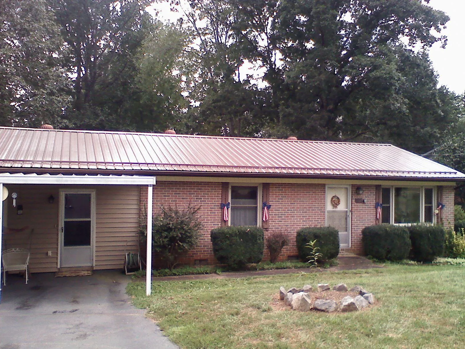 Bronze metal roof and carport on a brick ranch home — Roof Repair work by our crew in South Lebanon